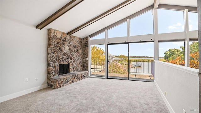 unfurnished living room featuring carpet flooring, a water view, beamed ceiling, and plenty of natural light