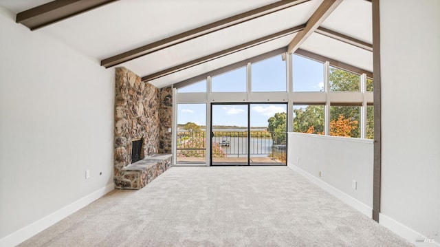 unfurnished living room featuring carpet, beam ceiling, a water view, and a fireplace