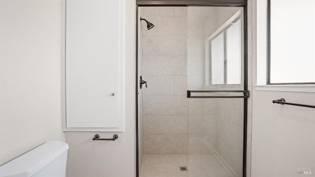 bathroom with toilet and an enclosed shower