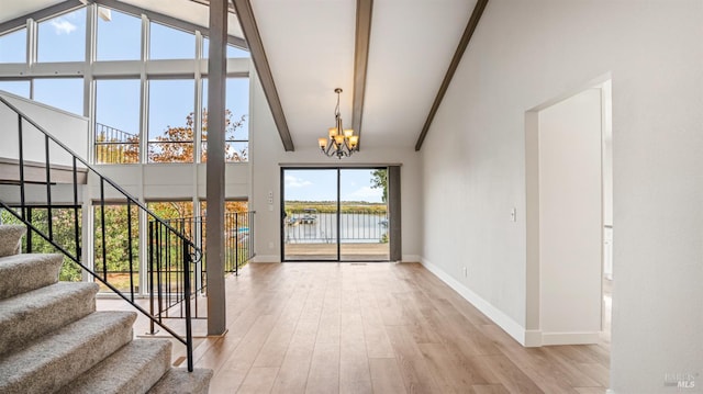 foyer with light hardwood / wood-style floors, a water view, beam ceiling, and high vaulted ceiling