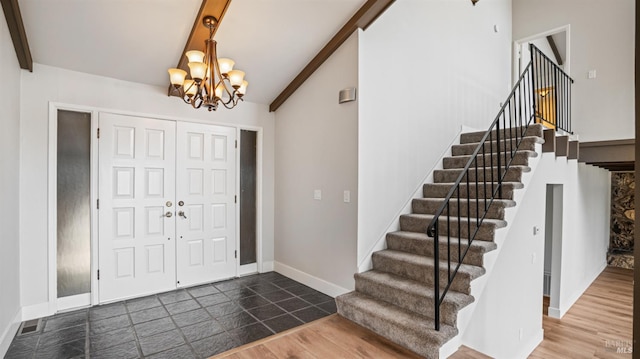 entryway with lofted ceiling with beams, dark hardwood / wood-style floors, and an inviting chandelier