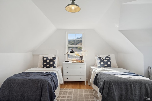 bedroom featuring lofted ceiling and light wood-type flooring