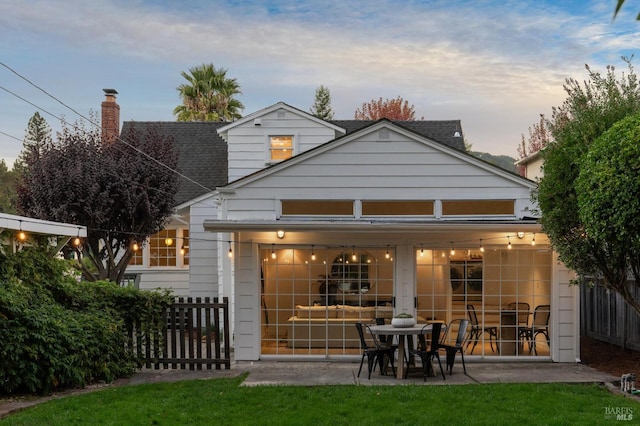 back house at dusk with a patio area