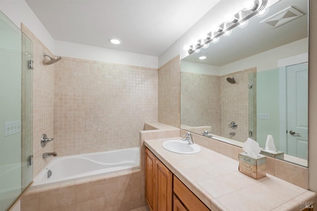 bathroom featuring tiled shower / bath combo and vanity