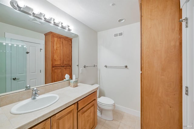 bathroom with vanity, toilet, and tile patterned floors