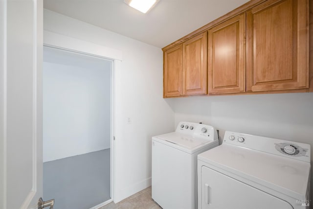 washroom featuring cabinets, light tile patterned floors, and washing machine and dryer