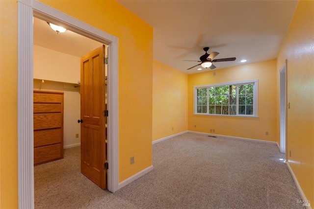 carpeted spare room with ceiling fan