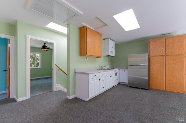 kitchen featuring white cabinetry, white appliances, and dark colored carpet