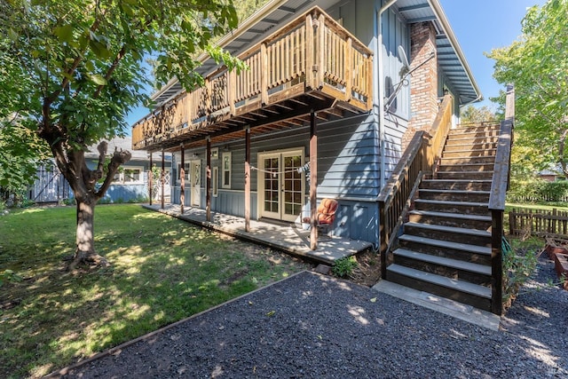 back of house featuring a yard, a deck, and a patio area