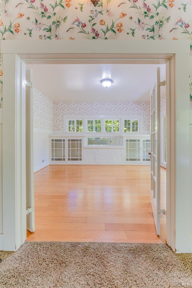 unfurnished living room featuring hardwood / wood-style flooring and plenty of natural light