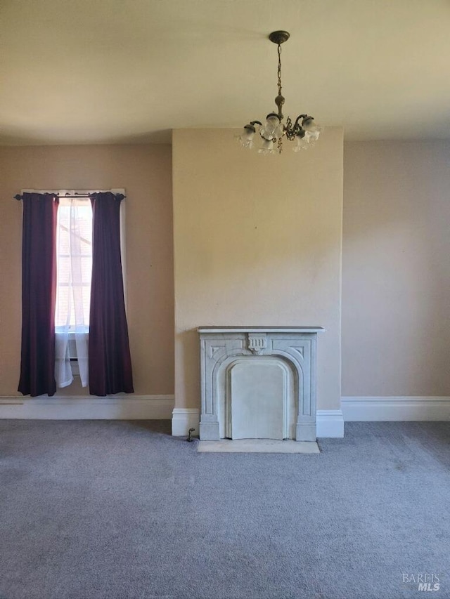 unfurnished living room featuring a chandelier and carpet floors