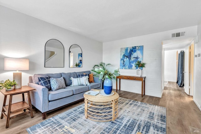 living area featuring visible vents and wood finished floors