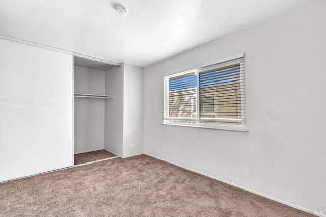 unfurnished bedroom with carpet floors, a closet, and a textured ceiling