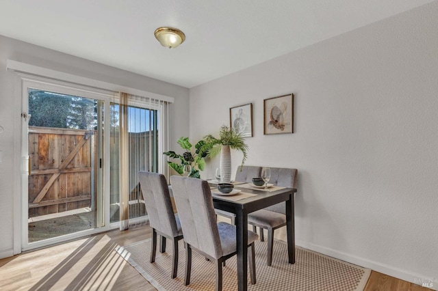 dining area featuring baseboards and light wood-type flooring