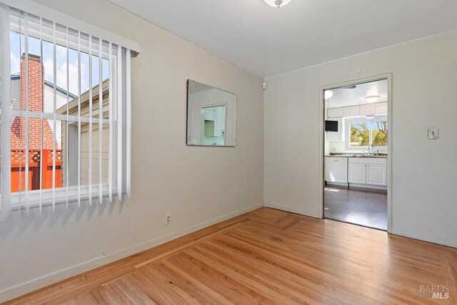 unfurnished room featuring light wood-type flooring and sink