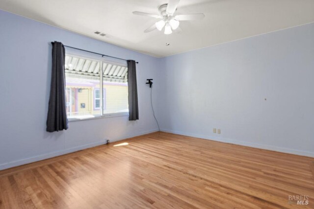 unfurnished room with hardwood / wood-style floors and ceiling fan