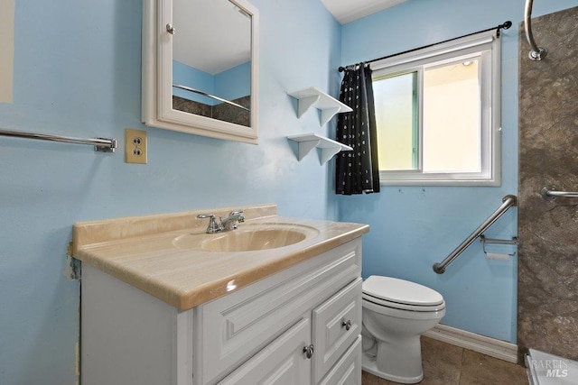 bathroom with tile patterned flooring, baseboards, vanity, and toilet