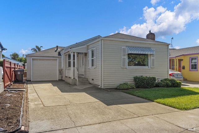 view of front of property with concrete driveway, a front yard, a chimney, and a garage