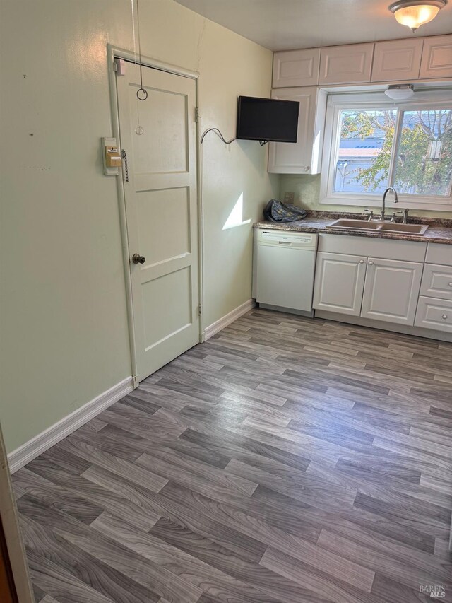 kitchen with white cabinetry, dishwasher, light hardwood / wood-style floors, and sink