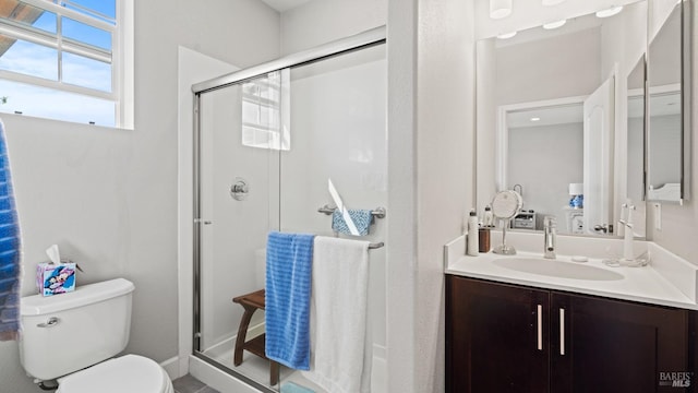 bathroom with an enclosed shower, vanity, and toilet