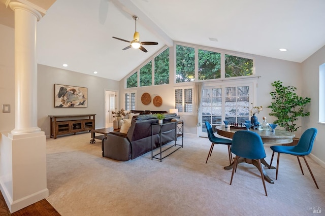 carpeted living room with ceiling fan, decorative columns, high vaulted ceiling, and a healthy amount of sunlight