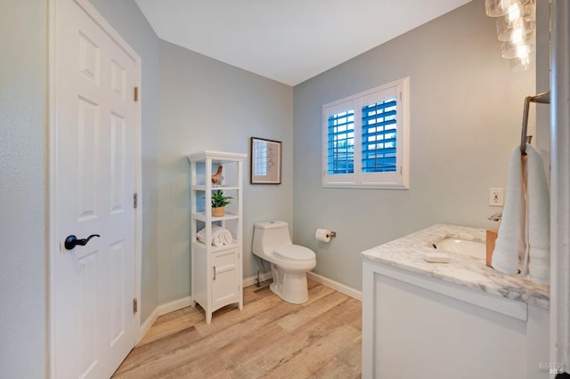 bathroom with wood-type flooring, vanity, and toilet