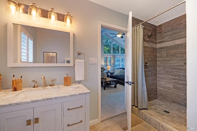 bathroom featuring ceiling fan, vanity, vaulted ceiling, walk in shower, and tile patterned flooring