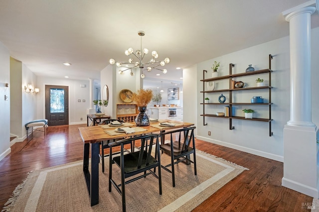 dining room with ornate columns, a notable chandelier, and dark hardwood / wood-style flooring