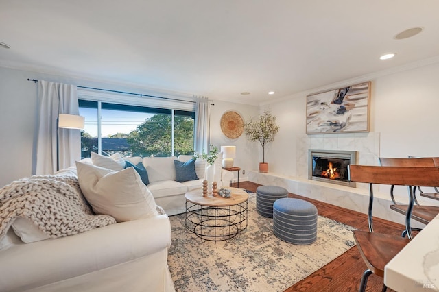 living room with ornamental molding, hardwood / wood-style floors, and a premium fireplace