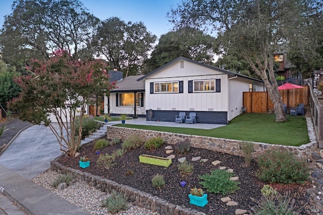 view of front of house featuring a front lawn and a patio