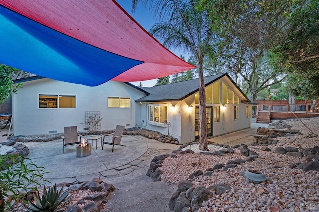 back house at dusk with a patio