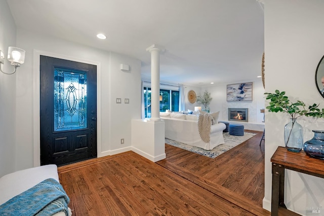 foyer featuring wood-type flooring and ornate columns