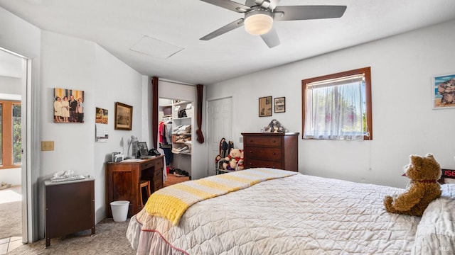 bedroom featuring a closet, light colored carpet, multiple windows, and ceiling fan