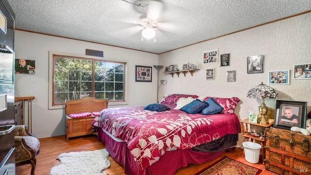 bedroom with ceiling fan, ornamental molding, a textured ceiling, and hardwood / wood-style floors