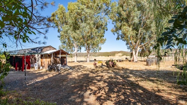 view of yard with a rural view and an outbuilding