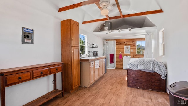 interior space with ceiling fan, sink, light hardwood / wood-style flooring, vaulted ceiling with beams, and washer / clothes dryer