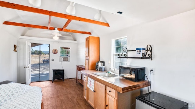 kitchen with plenty of natural light, sink, vaulted ceiling with beams, and tile counters