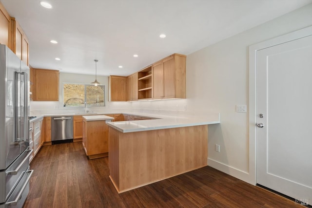 kitchen with kitchen peninsula, hanging light fixtures, stainless steel appliances, dark hardwood / wood-style flooring, and light brown cabinetry