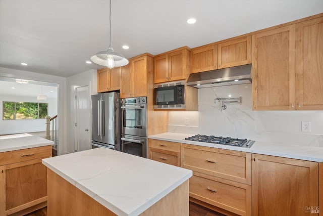 kitchen featuring hanging light fixtures, a kitchen island, stainless steel appliances, dark hardwood / wood-style floors, and light stone countertops