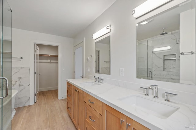 bathroom with wood-type flooring, vanity, and an enclosed shower