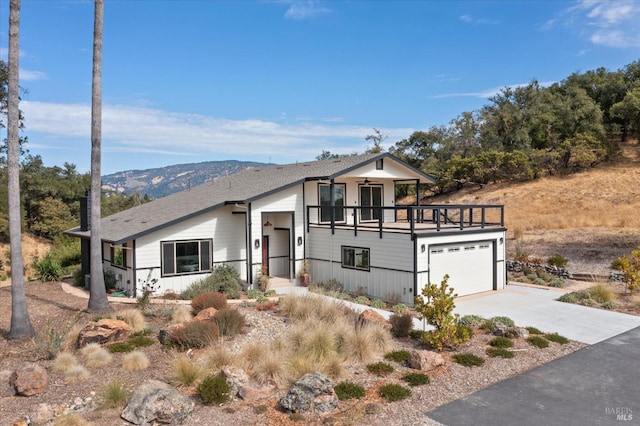 view of front of property with a balcony, a mountain view, and a garage