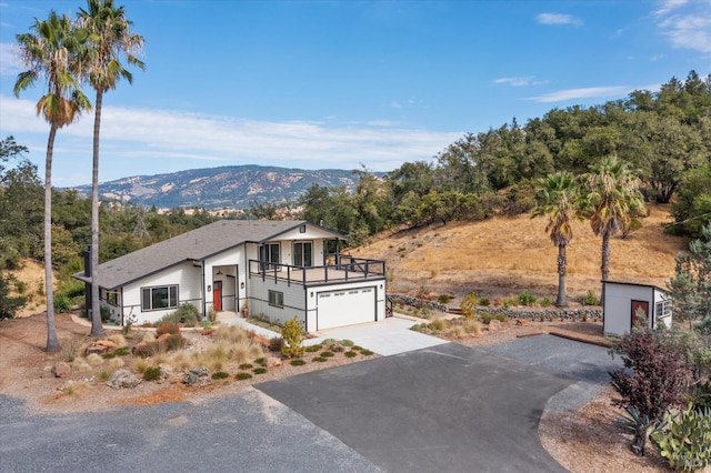 view of front of property with a balcony, a garage, and a mountain view