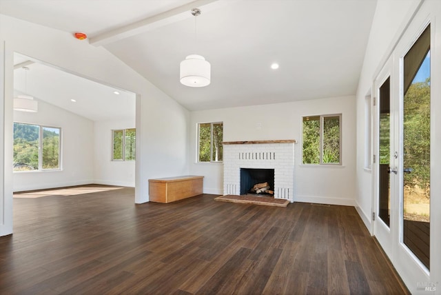 unfurnished living room featuring a fireplace, lofted ceiling with beams, dark hardwood / wood-style floors, and plenty of natural light