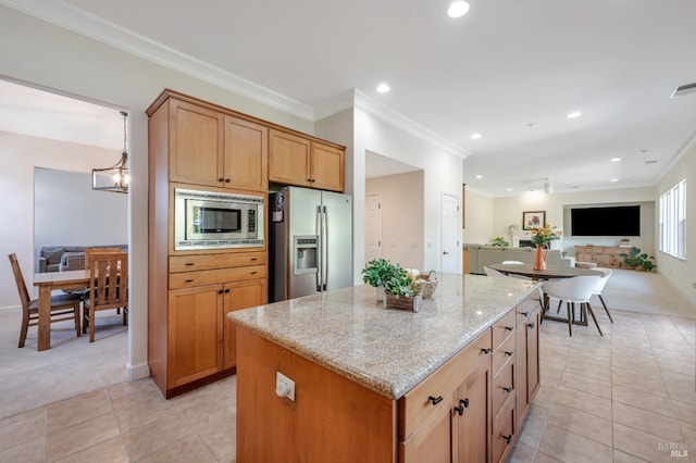 kitchen with a center island, light carpet, crown molding, light stone countertops, and stainless steel appliances