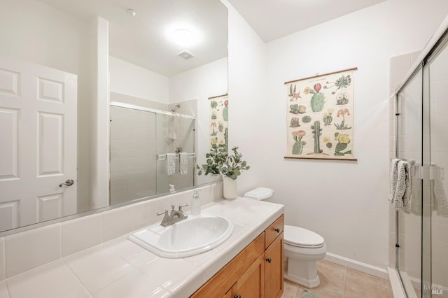 bathroom featuring tile patterned floors, vanity, toilet, and walk in shower