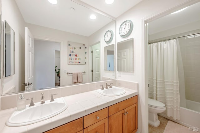 full bathroom featuring tile patterned floors, shower / bath combo with shower curtain, vanity, and toilet