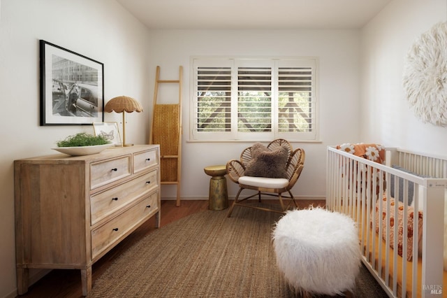 bedroom featuring a crib and dark hardwood / wood-style floors