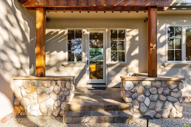 living room with beam ceiling, a stone fireplace, light hardwood / wood-style flooring, and high vaulted ceiling