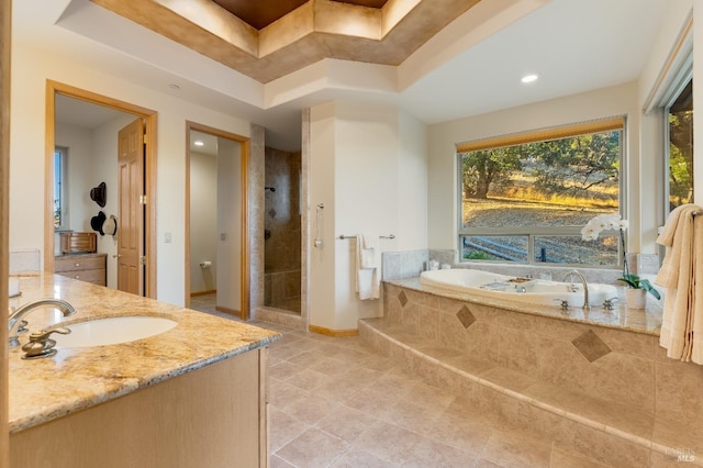 bathroom featuring vanity, a raised ceiling, and independent shower and bath