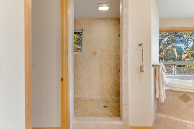 bathroom featuring a wealth of natural light and shower with separate bathtub